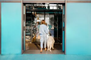 Woman with dog entering a Supermarket through Automatic Doors
